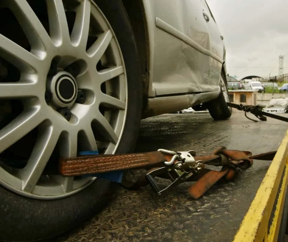 flatbed tow truck securing vehicle on regional highway