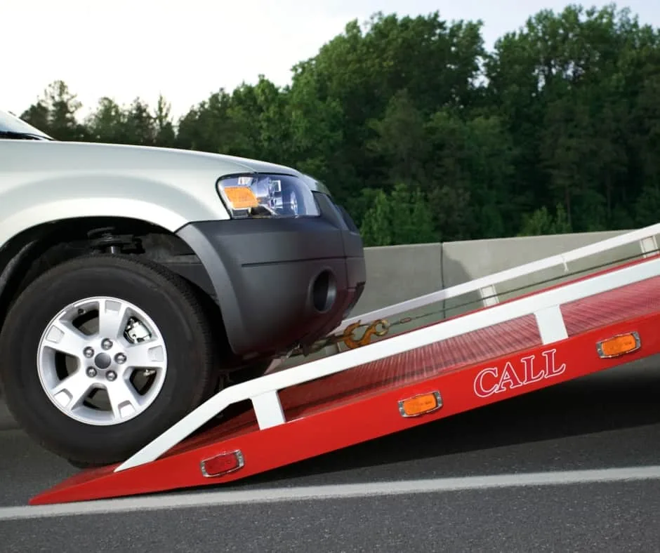 Orleans tow truck loading a vehicle on a residential street