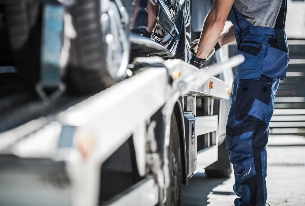Orleans tow truck driver loading a car onto a flatbed
