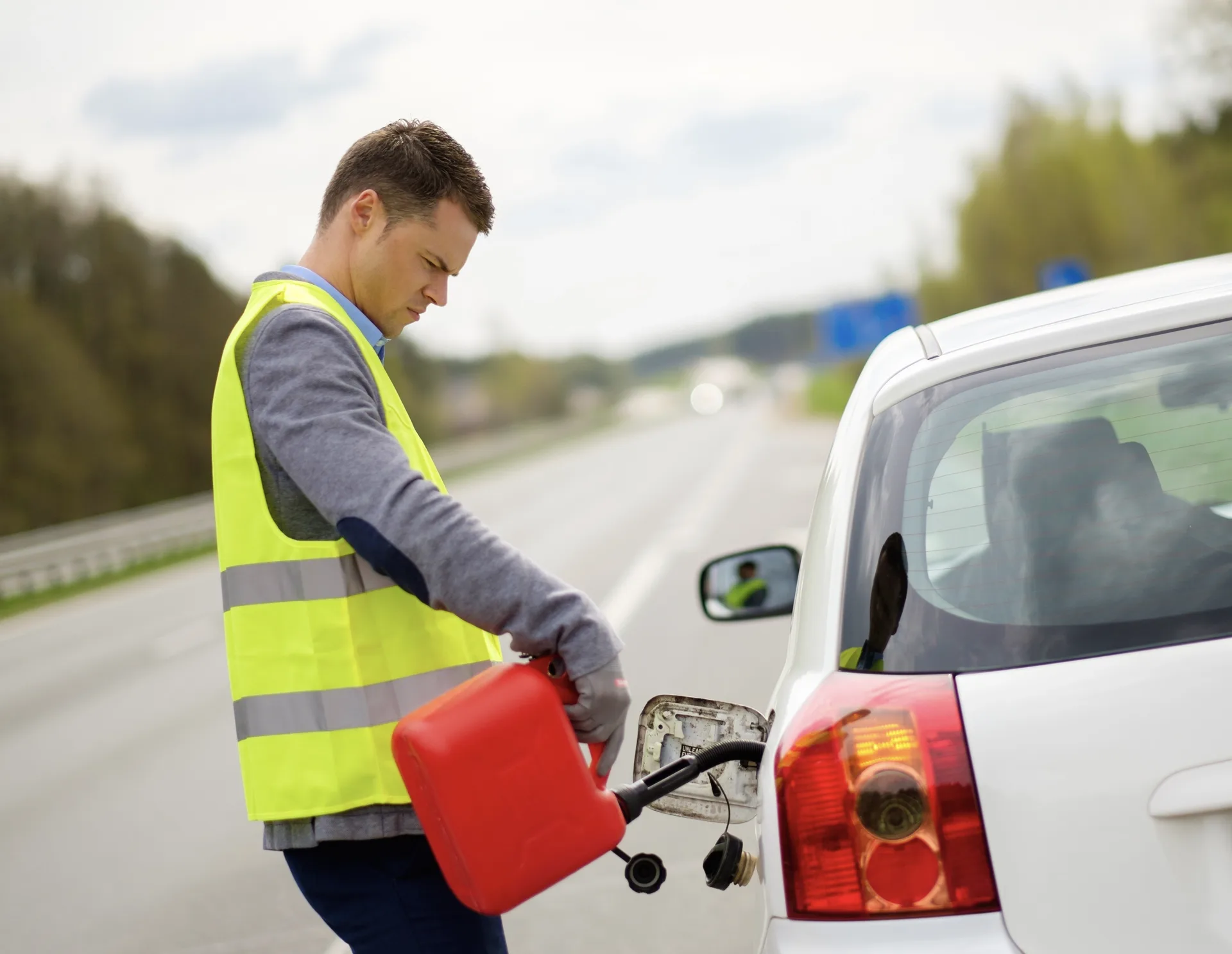 tow truck operator delivering fuel roadside